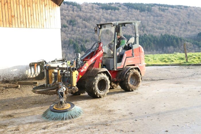 Vlat de ferme électrique weidemann équipé d'une brosse pour le nettoyage des logettes.